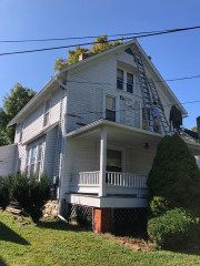 The team has finished scraping off old paint from this house and begins priming it. The final paint colors are shown in the above picture of the Chardon Century home with contrasting blue colors