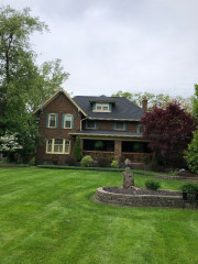 Freshly painted yellow trim and blue shutters on a brick house built in 1913 in Lakewood near Lake Erie