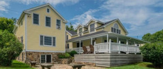 A large Century house in Chardon painted yellow with white trim and deck railings